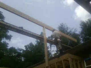 Carpenter setting a ridge beam over a new addition frame — Ice Dam Removal by Roofing Brothers in Western Springs