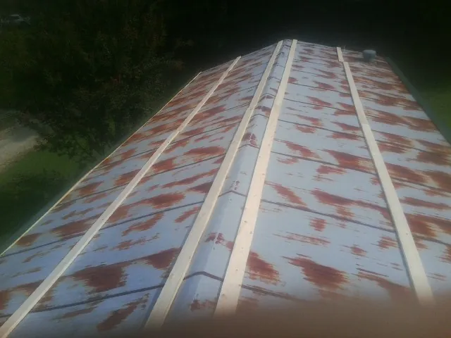 Rusted metal roof panels with new wood purlins before replacement — Storm Damage Roof Repair in Western Springs by Roofing Brothers